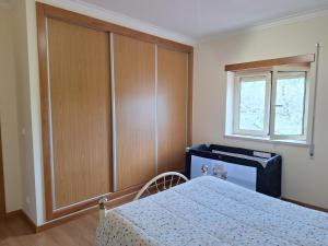 a bedroom with a bed and a dresser and a window at Casa do Pastana in Ancião