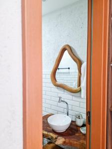 a bathroom with a sink and a mirror at Casa de Condomínio ao lado da Capela de Milagres in São Miguel dos Milagres