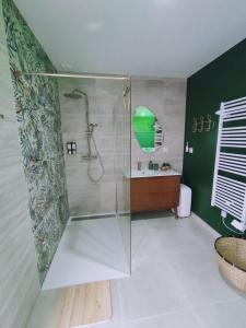 a bathroom with a glass shower and a sink at Une virée à deux, gîte et spa in Guiscard