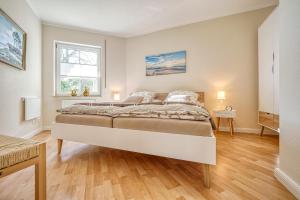 ein Schlafzimmer mit großem Bett und Fenster in der Unterkunft An der alten Rotbuche 02 in Zingst + 12 Fotos