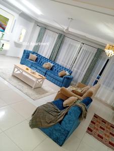a living room with a blue couch and a table at Luxurious Spacious 3bedroom apartment Nyali Mombasa in Mombasa