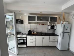 a kitchen with white cabinets and a white refrigerator at Serranias de Tandil in Tandil
