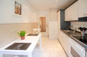 een keuken met witte kasten en een wit aanrecht bij Ferienwohnung Amselnest in Bad Sachsa +11 foto's