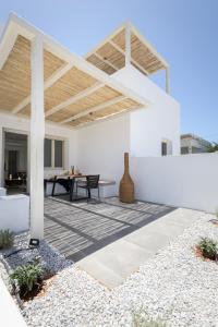 a white patio with a table and a wooden roof at Azimuth Houses in Pollonia