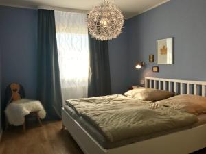 une chambre avec un lit et un lustre dans l'établissement Ferienhaus Nr 128, Kategorie Komfort Plus L, Feriendorf Hochbergle, Allgäu, à Lechbruck am See