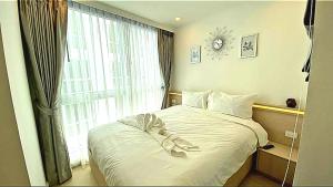 a bedroom with a white bed with a bow on it at River View Active 3 in Bangkok