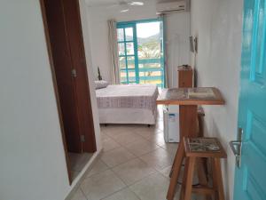 a room with a bedroom with a bed and a window at Pousada Gaucha Caiobá in Matinhos
