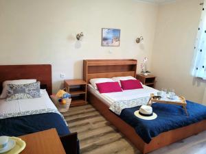 a bedroom with two beds with red pillows and a table at Dom Pod Jeleniem in Łeba