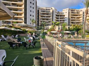 ラーナナにあるLovely and Bright Apart, 2 Bed, 2 Bath, sleeps 5, Swimming pool - Jacuzzi & Gymのバルコニー(テーブル、椅子付)、プールが備わります。