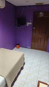 Camera viola con letto e porta di HOTEL MEDAN KiDD a Ipoh