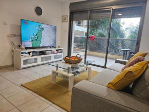 ラーナナにあるLovely and Bright Apart, 2 Bed, 2 Bath, sleeps 5, Swimming pool - Jacuzzi & Gymのソファと薄型テレビのあるリビングルーム