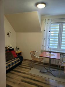 a living room with a table and a couch at Dom Pod Jeleniem in Łeba