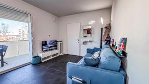 ein Wohnzimmer mit einer blauen Couch und einem Fernseher in der Unterkunft Fano Centro Mare in Fano