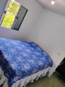 a bed in a room with a window at Casinha no Centro in Santo Antônio do Pinhal