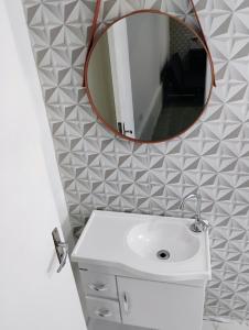 a bathroom with a white sink and a mirror at Casinha no Centro in Santo Antônio do Pinhal +24 photos