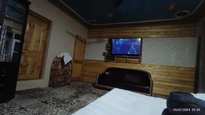 ein Zimmer mit Fernseher und Bett und ein Zimmer mit Bett sidx sidx in der Unterkunft De brook in Srinagar