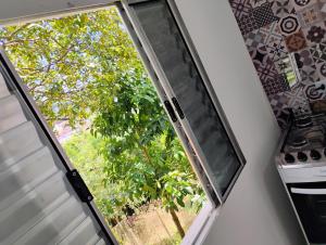 a sliding glass door with a view of a tree at Casinha no Centro in Santo Antônio do Pinhal