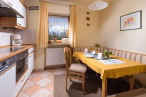 a kitchen with a table with a yellow table cloth at Gästehaus Lärcheck Berchtesgaden FeWo Gipfelzauber in Berchtesgaden