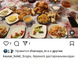 a table with plates of food on a table at Kausar guest house in Karabulak