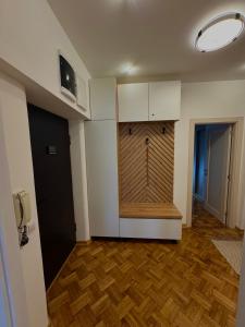 ein Raum mit einer Holzwand, an der eine Uhr hängt in der Unterkunft Lex apartment in Belgrad + 4 Fotos