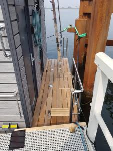 a wooden dock on the front of a boat at exclusives Hausboot "Tante Trost" in Heiligenhafen +7 photos