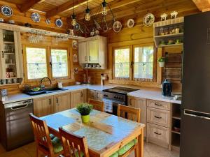 a kitchen with wooden cabinets and a table with chairs at Letnia Chata u Romana in Zalewo
