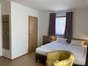 a bedroom with a bed and a yellow chair at Zenntaler Hof in Neuhof an der Zenn