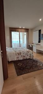 脉泽TERRAZZA SAN VETTORE camere con colazione, Relax in collina con vista sui vigneti DOCG ASOLO的一间卧室设有床、窗户和地毯。