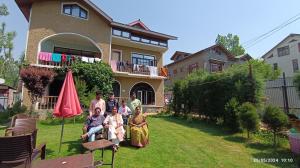 Eine Gruppe von Menschen steht vor einem Haus in der Unterkunft De brook in Srinagar