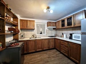 a kitchen with wooden cabinets and white appliances at Casa Chindea Lacu Rosu in Lacu Rosu