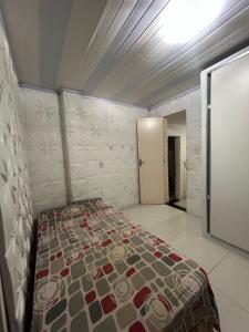 a small bedroom with a bed in a room at Quarto casa circuito Carnaval frente praia in Salvador