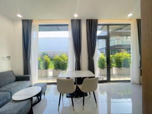 a living room with a table and chairs and a couch at DOME APARTMENT in Nhơn Trạch
