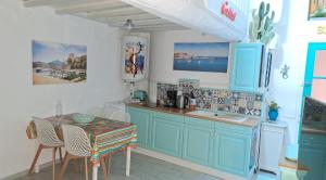 une cuisine avec des armoires bleues et une table et des chaises dans l'établissement Appartement typique 2 étoiles avec clim, à Collioure 17 autres photos