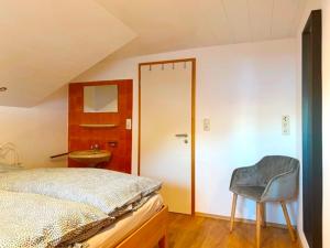 une chambre avec un lit et une chaise à côté d'une porte dans l'établissement Haus Dora Apartment 4 Panoramablick, à Mayrhofen