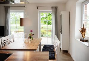 a dining room with a wooden table and a window at Bauernhof Höper-Rauert - Nr 9 Wellnesshaushälfte in Neujellingsdorf