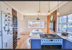 a kitchen with a stove and a refrigerator at OceansCrest Seaview Apartment in Bettyʼs Bay