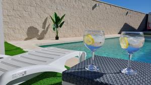 zwei Weingläser auf einem Tisch neben einem Pool in der Unterkunft La Casita de la Piscina in Burguillos de Toledo + 10 Fotos