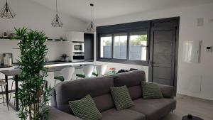 ein Wohnzimmer mit Couch und Küche in der Unterkunft La Casita de la Piscina in Burguillos de Toledo