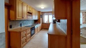a kitchen with wooden cabinets and a stove top oven at Ferienwohnung Nr 1, Lechbruck-Gründl, Allgäu in Prem