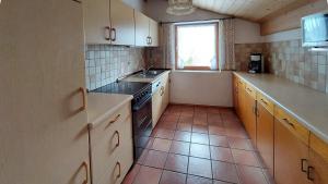 a small kitchen with white cabinets and a window at Ferienwohnung Nr 4, Lechbruck-Gründl, Allgäu in Prem