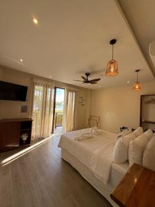a bedroom with a bed and a ceiling fan at Chellie Rose Resort Hotel in Bantayan Island +39 photos