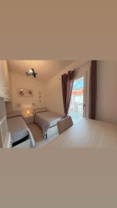 een slaapkamer met twee bedden en een raam bij Virgilio's House in Tertenìa