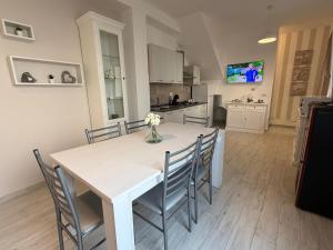 a kitchen and dining room with a white table and chairs at Virgilio's House in Tertenìa +12 photos