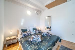 a bedroom with a bed with pillows and a mirror at Moenia Apartments in Milna +228 photos