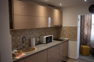 a kitchen with a sink and a microwave at Ale Apartament aproape de facultate de medicina Vasile Goldis in Arad +14 photos