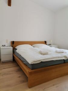 a bed with white sheets and a wooden headboard at Ferienwohnung Neukalen in Neukalen