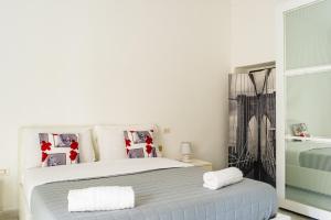 a bedroom with a white bed with two pillows at da Lulu' Casa Vacanze Gargano in Vico del Gargano