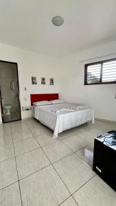 a bedroom with a large bed and a bathroom at Suíte House Pipa in Pipa