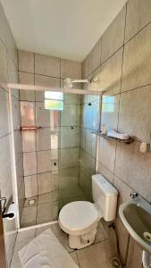 a bathroom with a toilet and a sink at Suíte House Pipa in Pipa