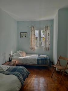 a bedroom with two beds and a window at Vila Mar in Porto Covo